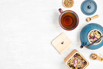 Obraz na płótnie Canvas Traditional tea ceremony setup, teapot and teacup with herbs and dry fruits tea. Tisane detox, relaxation, healing, healthy comforting, tea time concept. Top view, flat lay