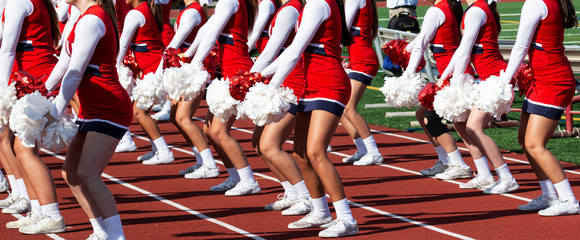 Cheerleaders on the sidlines performong for the crowd