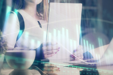 Double exposure of hands making notes with forex chart huds. Stock market concept.