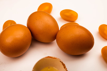 Chicken eggs and tomatoes on a white background. Close up.
