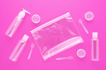 travel toiletries, small plastic bottles for hygiene products on pink background