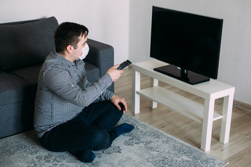 angry man wearing mask watching tv news