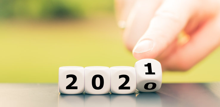 Hand turns dice and changes the year "2020" to "2021".