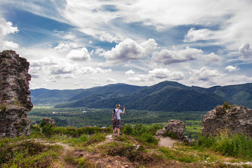 Fototapeta na wymiar woman tourist takes phone mountain view