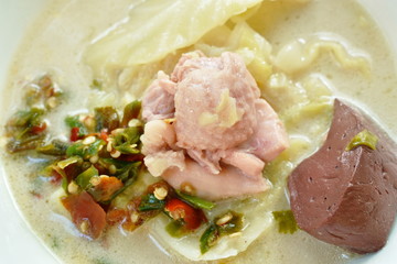 spicy boiled chicken meat and blood with slice cabbage in coconut milk soup on bowl