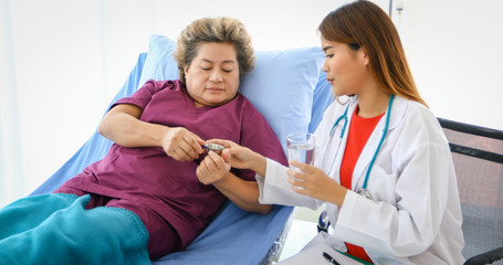 Obraz premium The doctor is asking and explaining the illness and giving the medicine With old women patients at the hospital.