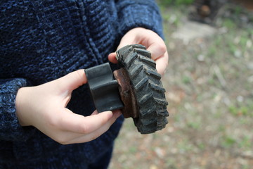 A high angle closeup shot of a human hand holding a small toy wheel
