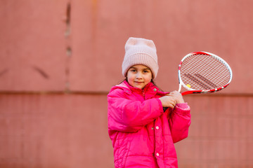 Little cute girl playing tennis outdoors