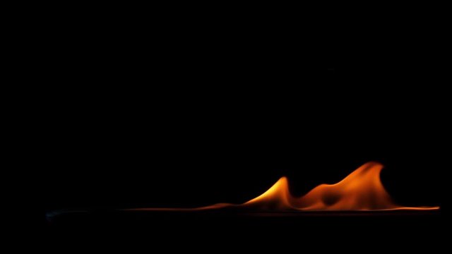 Slow motion speed close up scene on burning sparking pattern rise up on floor isolated on black background, fast spread of blue hot flame above fuel surface, blasting fire stream ignite on petroleum