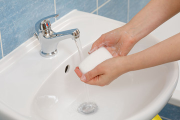 Hygiene concept. Washing hands with soap under the faucet with water
