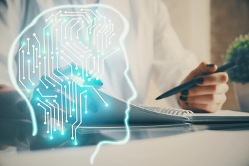 Multi exposure of writing hand on background with brain hologram. Concept of self learning.