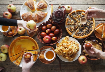 Feast, Easter food, treats with Easter cakes and colored eggs.Hands of people eating food at the table.