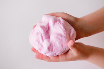 pink slime or handgum toy in kids hands. fluffy slime DIY project. leisure and home made toys concept. indoors activities during quarantine.