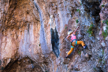 A girl climbs a rock.