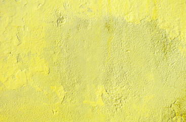 Fragment of old house wall close-up. Yellow background. Peeling plaster on concrete surface. Cracks in paint. tinted in yellow, warm colors backdrop. Copy space. Place for text. Selective focus image.