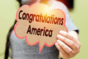closeup woman holding speech bubble card with Congratulations America