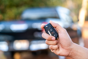 a hand of man opens the door of car by car key