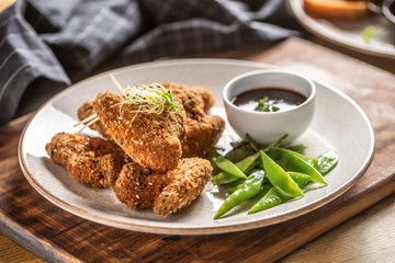 Fried chicken wings with sugar peas and herbs