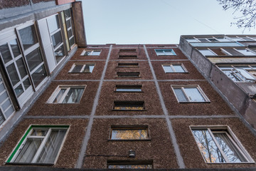 Symmetric facade of old soviet multistorey typical concrete apartment.