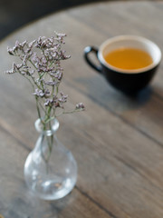 Dry flowers and tea cup on a wooden table