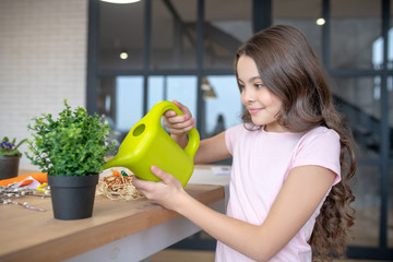 Long-haired cute girl watering flowers and smiling © zinkevych