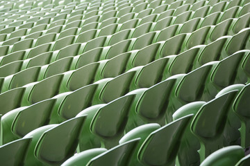 A row of empty green seats in a football stadium