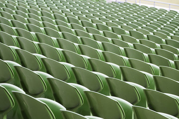 A row of empty green seats in a football stadium