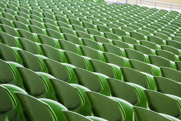A row of empty green seats in a football stadium