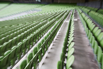 A row of empty green seats in a football stadium