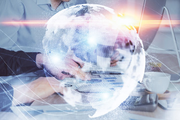 Double exposure of businessman working on laptop on background. International business hologram in front. Concept of success.