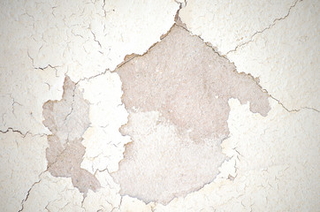Light building background. gray wall of old house closeup. White peeling plaster. Cracks on the surface of building or fence. City building concept. Copy space. Place for text. Selective focus image.