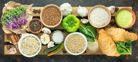 Healthy eating Super food: vegetables, fruits, herbs, cereals, croissants and spices on a wooden stand. Vegetarian food. Culinary background for recipes. Food background. Dark background.