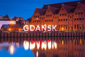 Plakaty  City of Gdansk outdoor sign over Motlawa river at dusk, Poland.