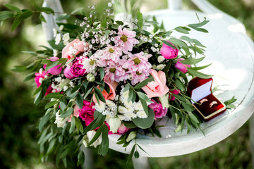 Partial view of florist holding bouquet of fresh flowers on wooden surface