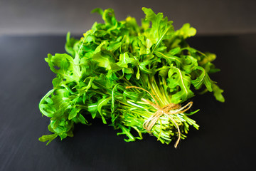 Arugula fresh leaves on black background