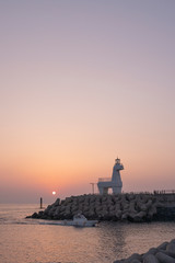 Horse-shaped lighthouse in the sea with a fantastic sun