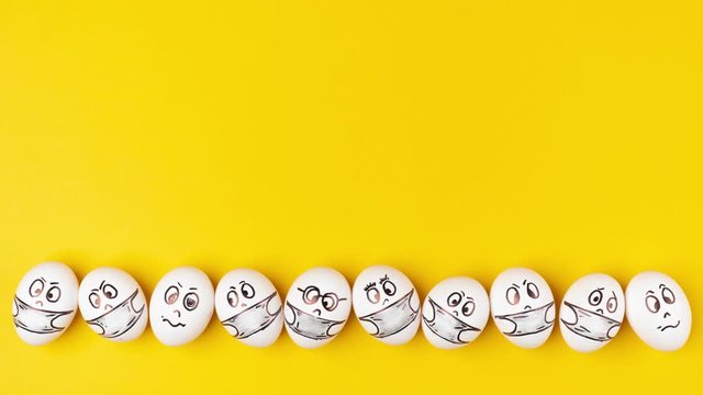 White eggs with painted faces in respiratory masks move on a yellow background. Emotions on the eggs. Stop motion animation