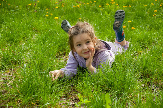 
Sweet little girl take a rest on the grass in the garden

