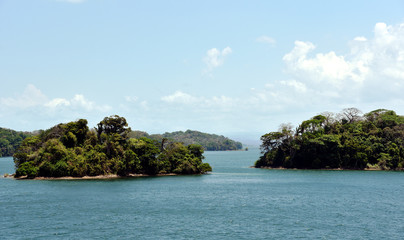 Green landscape of Panama Canal, view from the transiting cargo ship.