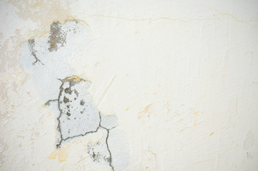 Light building background. gray wall of old house closeup. White peeling plaster. Cracks on the surface of building or fence. City building concept. Copy space. Place for text. Selective focus image.