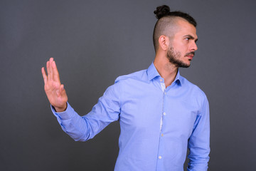 Portrait of serious bearded Turkish businessman with stop gesture