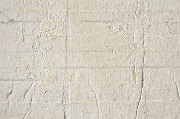 Light building background. gray wall of old house closeup. White peeling plaster. Cracks on the...