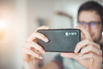 Social media content production with the smartphone. Close up of black smartphone camera lens indoors.