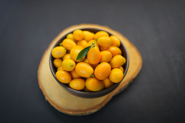 Kumquat in a bowl and on a black background