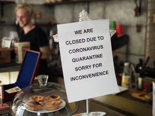 Biohazard concept of living in a new reality of coronavirus epidemic hysteria cafe owner sticks advertisement on quarantine measures to contain virus pinned on bar counter