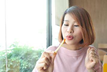 Women happy with french fries in her hands,Pink shirt women greeful for her french fries,Selective focus