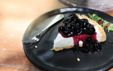 Blueberry Ceese pie cake put on black dish lay on wooden table,Relax time with coffee and cake,selective focus