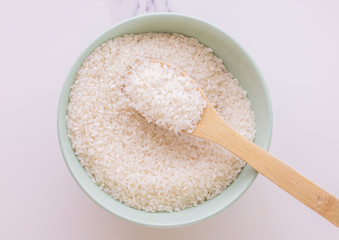 rice close-up in a ceramic green plate. Still life of sris on a wooden spoon