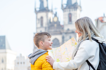 Fototapeta premium Happy family holds map on the old town square in Prague. Empty space for text