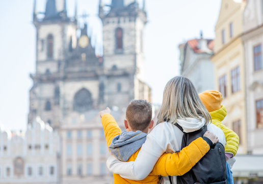 Happy Family Stands On The Old Town Square In Prague. Empty Space For Text